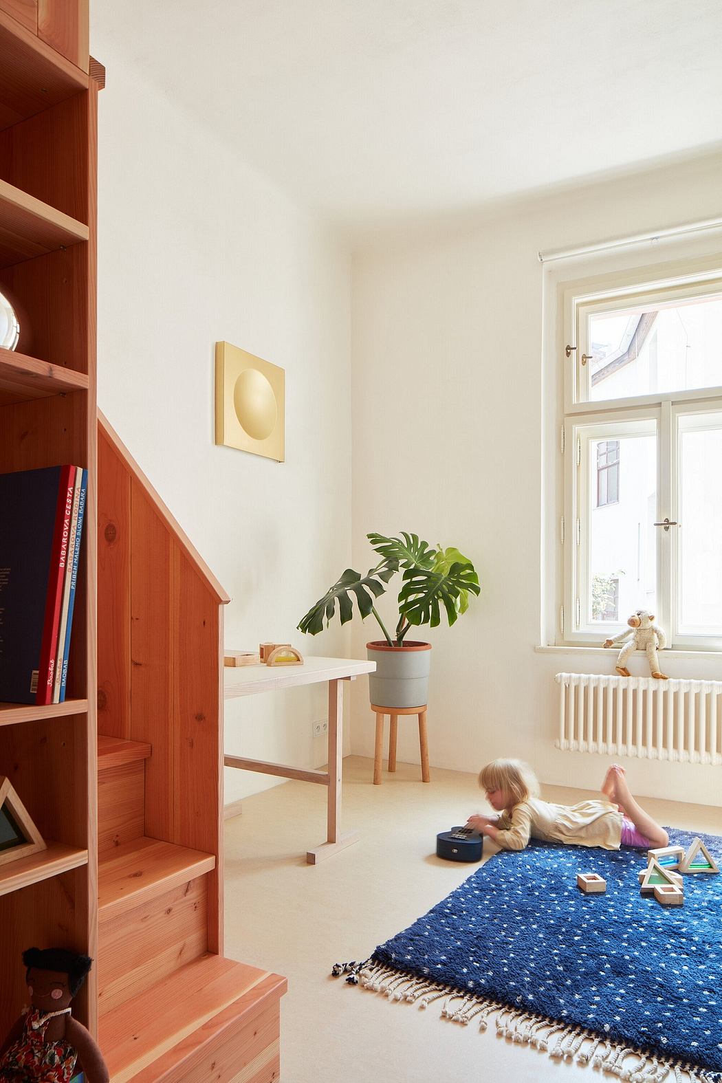 Cozy child's room with wooden shelving, potted plant, and patterned rug.