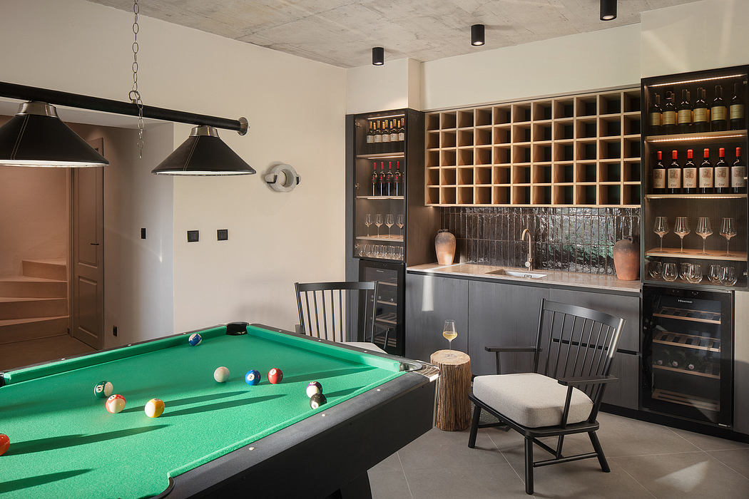 A modern, well-appointed home bar and game room with a pool table, wine racks, and industrial lighting.