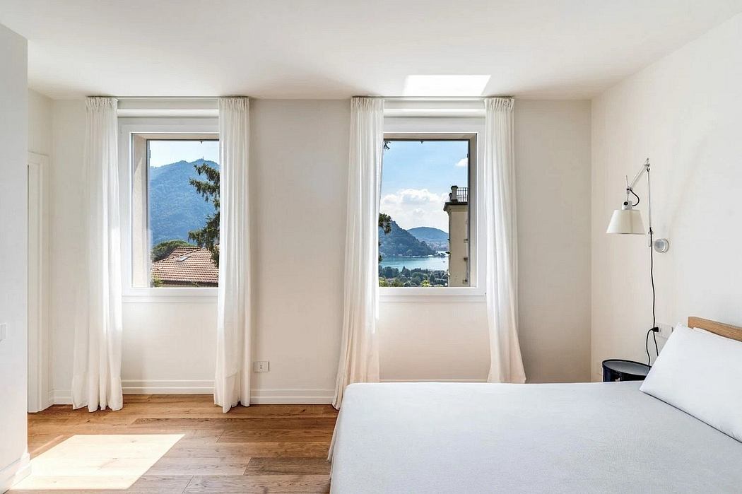 Bright, airy bedroom with large windows offering stunning mountain views and clean, minimal decor.