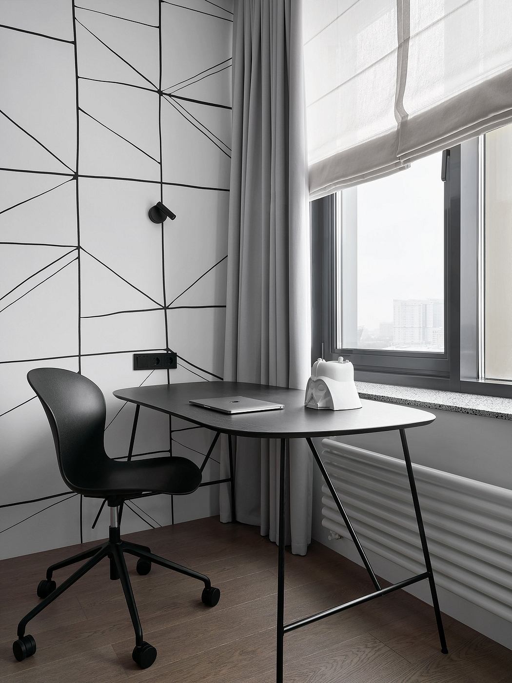 A minimalist workspace with a modern geometric wall pattern, large window, and sleek furniture.