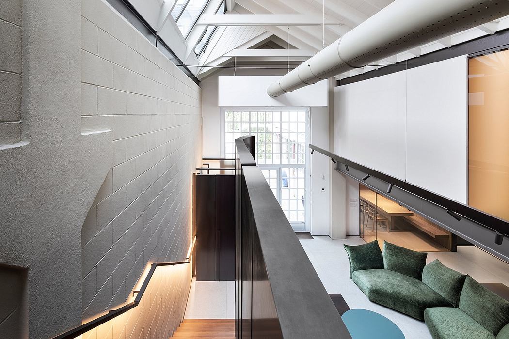 Bright industrial-style interior with exposed beams, sleek furniture, and glass walls.