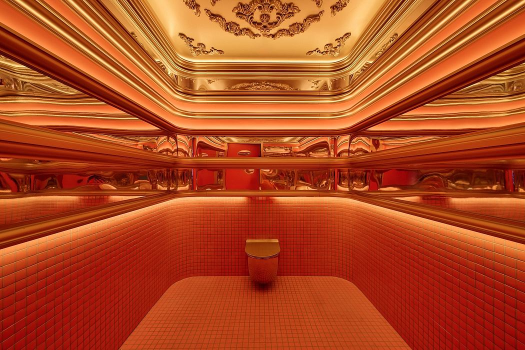 Ornate golden ceiling with intricate moldings and patterns in a luxurious red-tiled room.