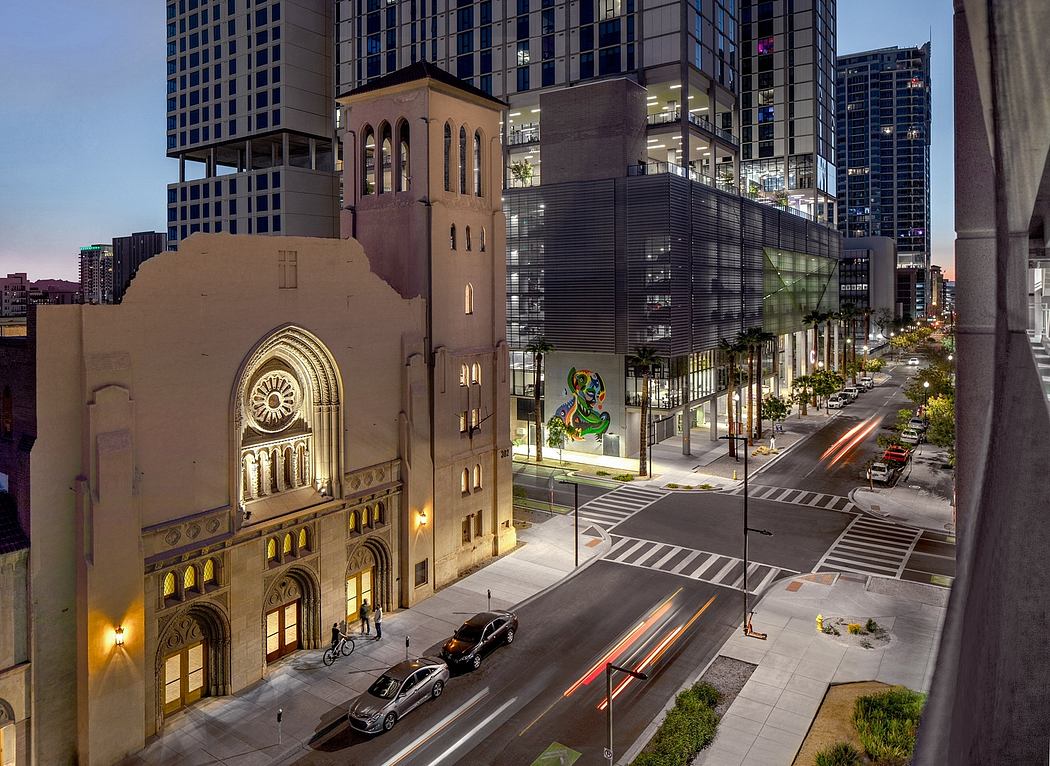 This image depicts a striking architectural contrast between a historic church and modern high-rise buildings in the city.