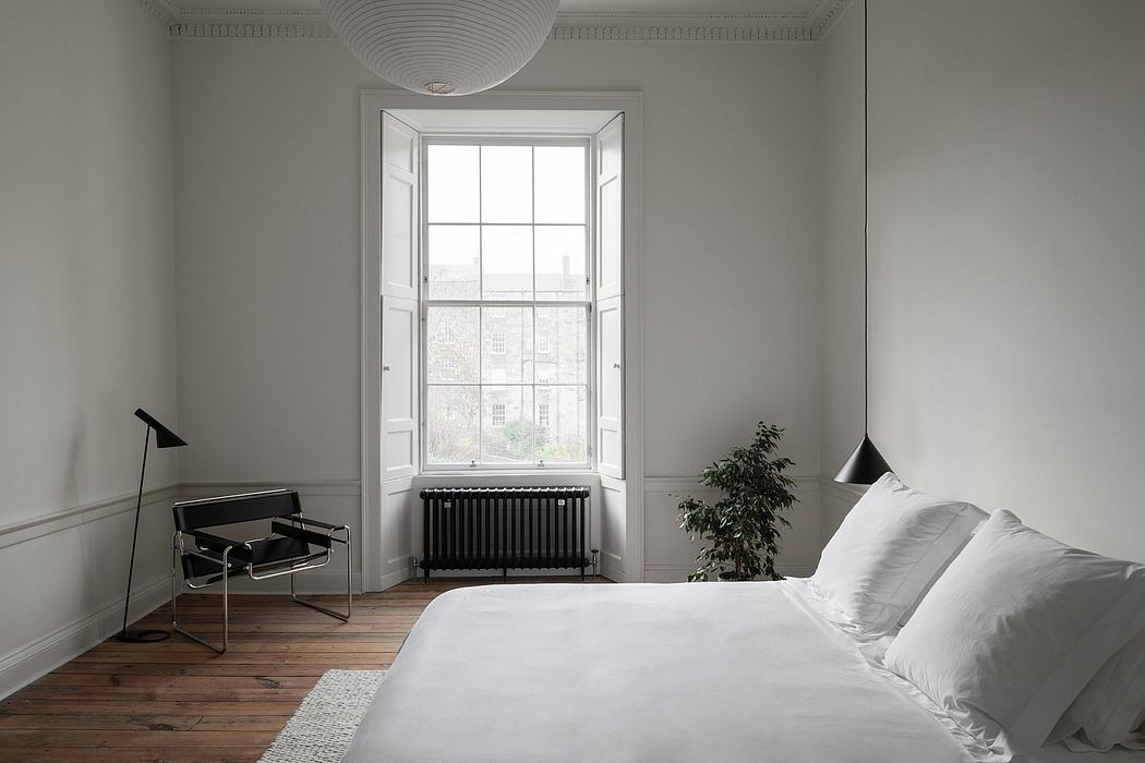 Spacious bedroom with ornate ceiling, large window, and minimal furnishings.