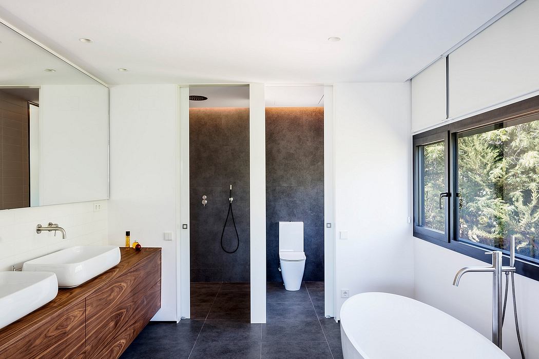 Sleek, modern bathroom with wooden vanity, tiled walls, and a freestanding bathtub.