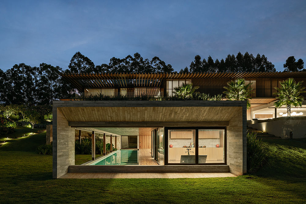 A modern, single-story home with an expansive outdoor terrace, pool, and lush landscaping.