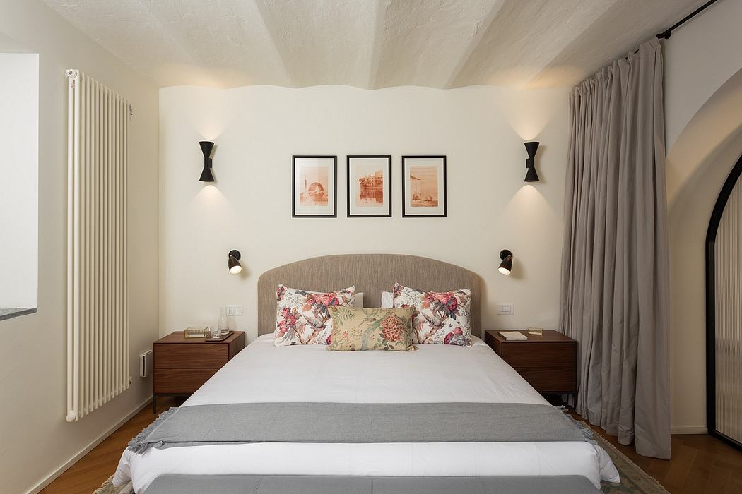 Cozy bedroom with curved upholstered headboard, wooden nightstands, and framed artwork.