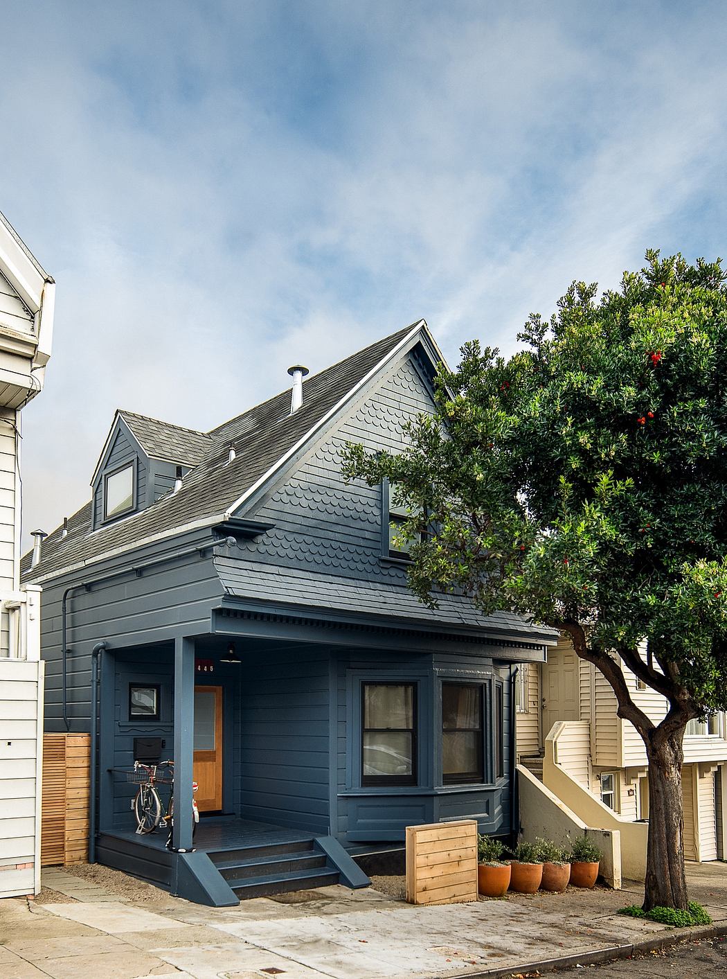 A charming two-story home with a gabled roof, bay windows, and a welcoming front porch.