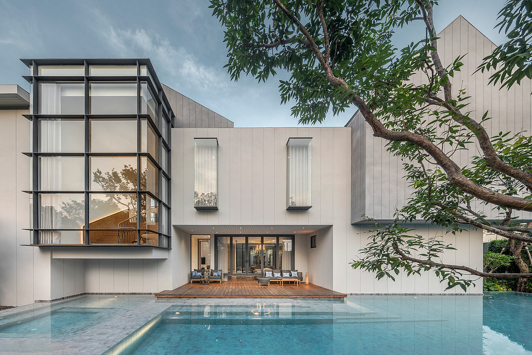 Sleek, modern architecture with glass walls, pool, and lush greenery surrounding.