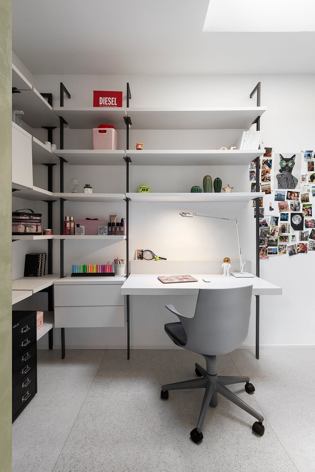Well-organized workspace with sleek white shelves, desk, and swivel chair. Minimalist decor with personal touches.