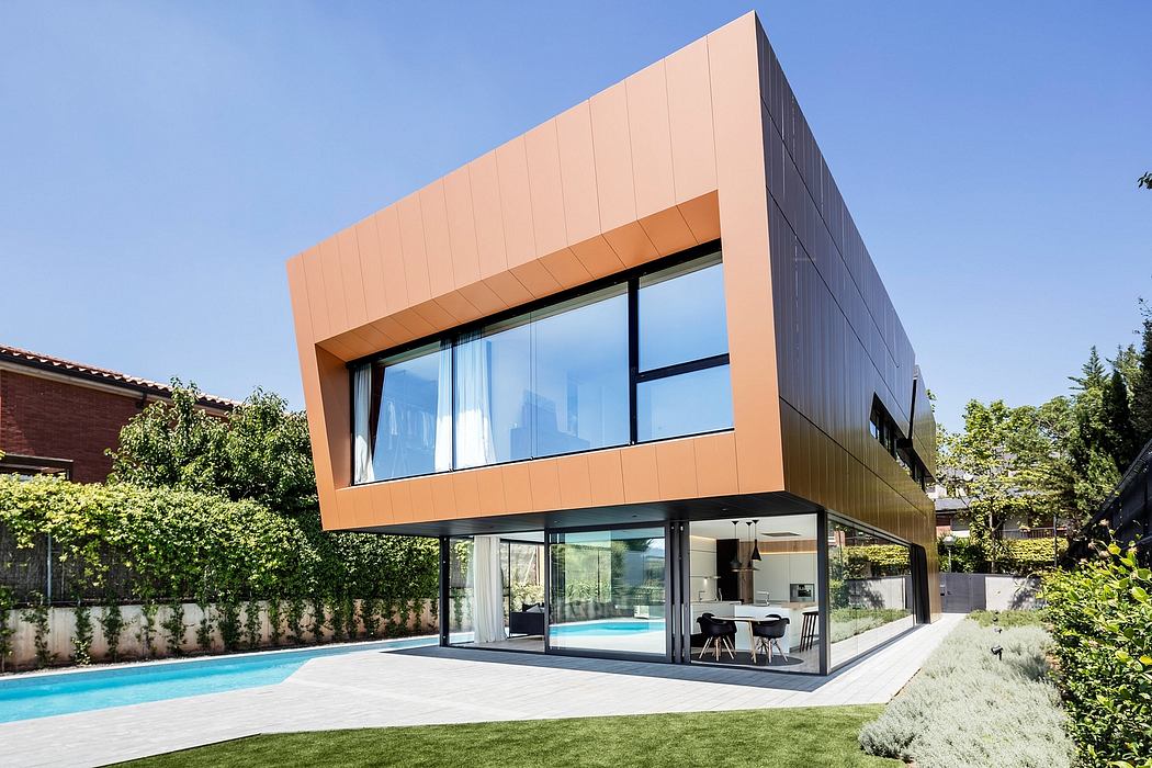A striking modern home with a bold copper-colored facade, large windows, and a backyard pool.