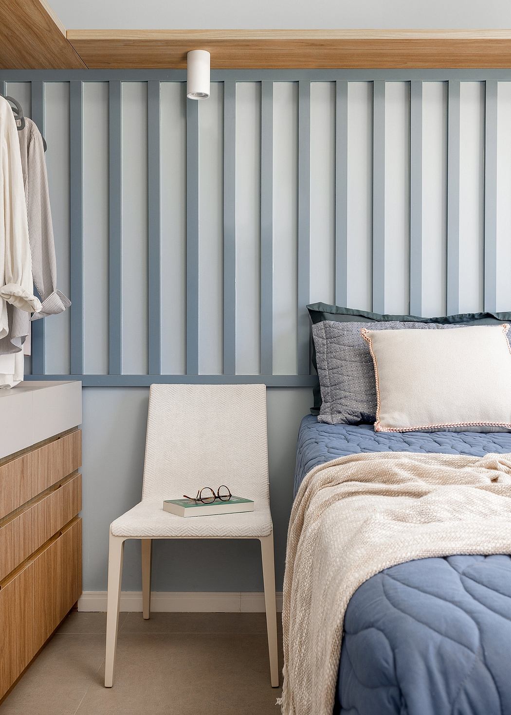 Cozy bedroom with wood paneled walls, built-in storage, and minimalist furnishings.