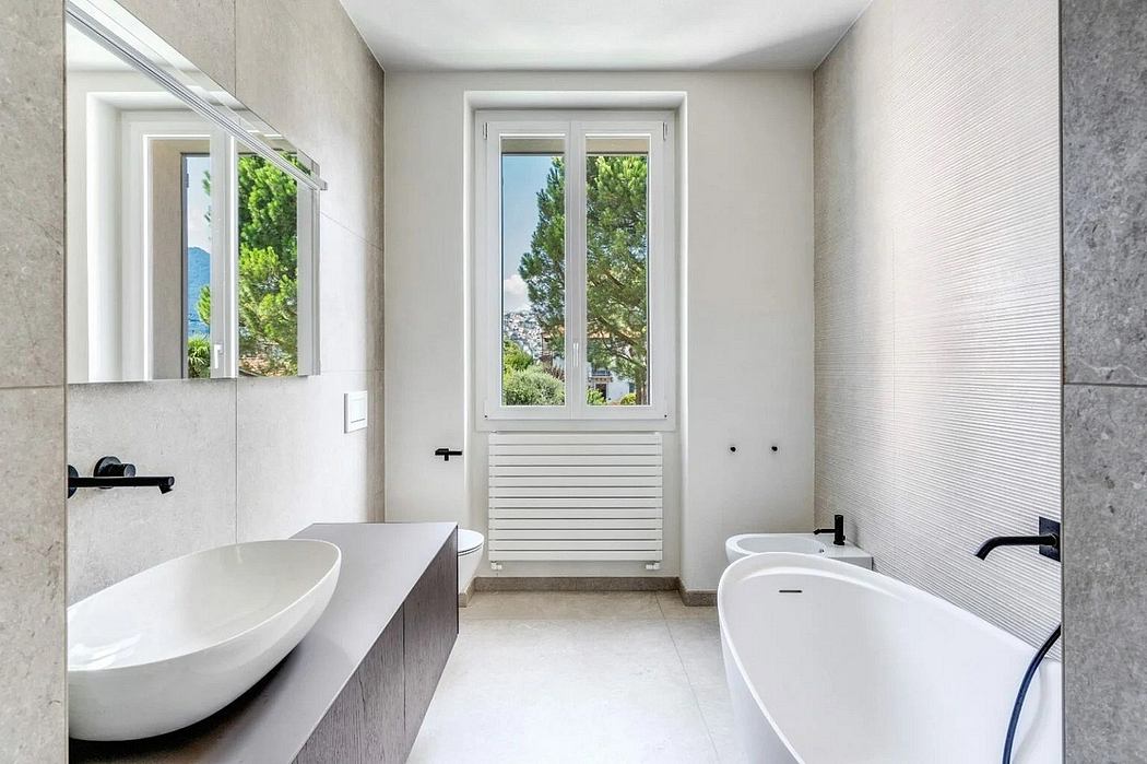 Modern, minimalist bathroom with large window, natural stone tiles, and sleek fixtures.