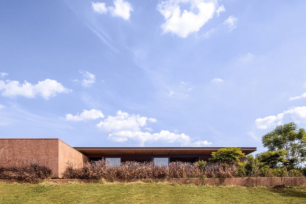 Low-profile modern building with extensive use of glass and warm wood tones.