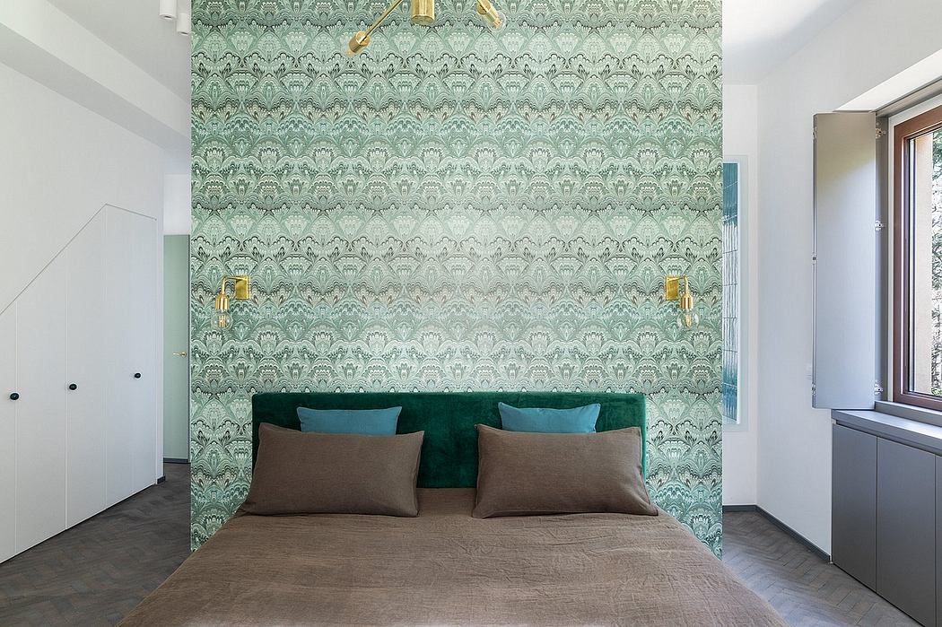 Elegant green and white patterned wallpaper, plush green and brown bedding, modern wall sconces.