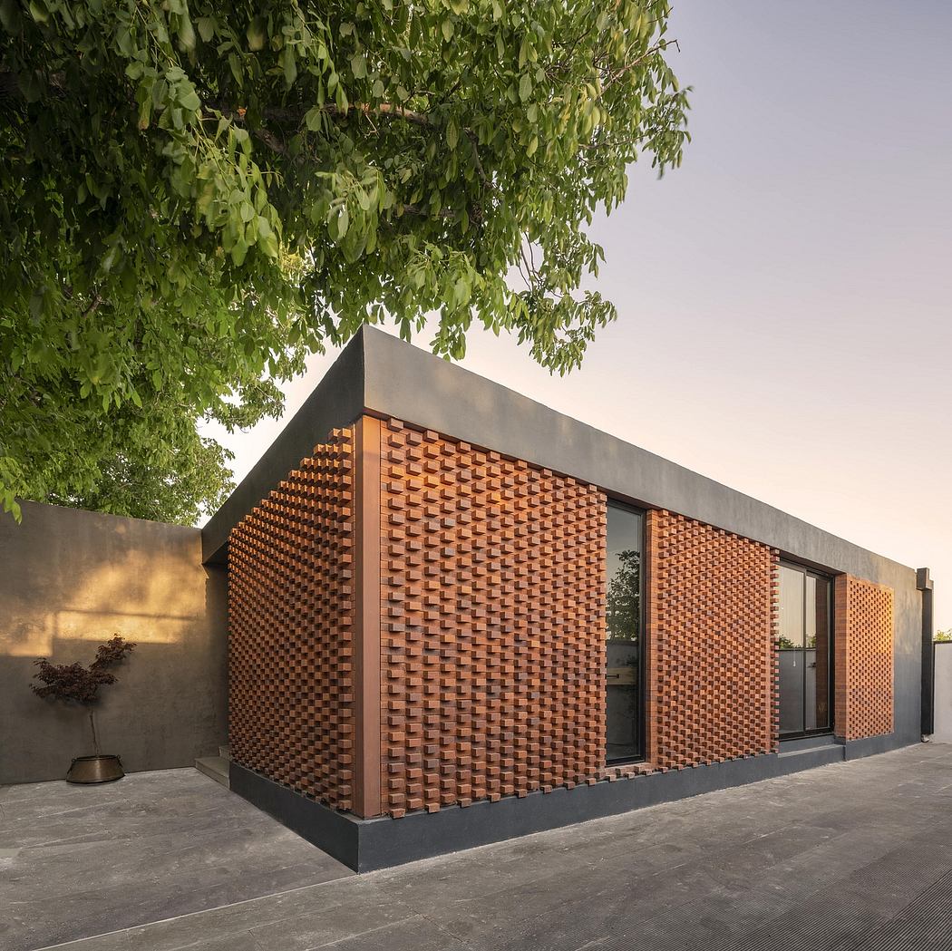 A modern building with a striking brick facade, complementing the surrounding greenery.