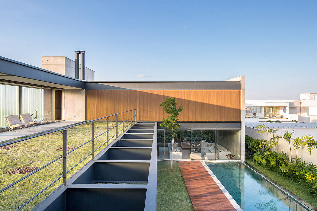 Modern, multi-level structure with wooden exteriors, glass walls, and a sleek pool feature.
