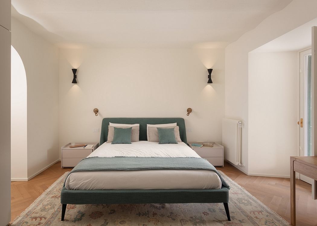 Cozy bedroom with plush bedding, sleek nightstands, and modern wall sconces.