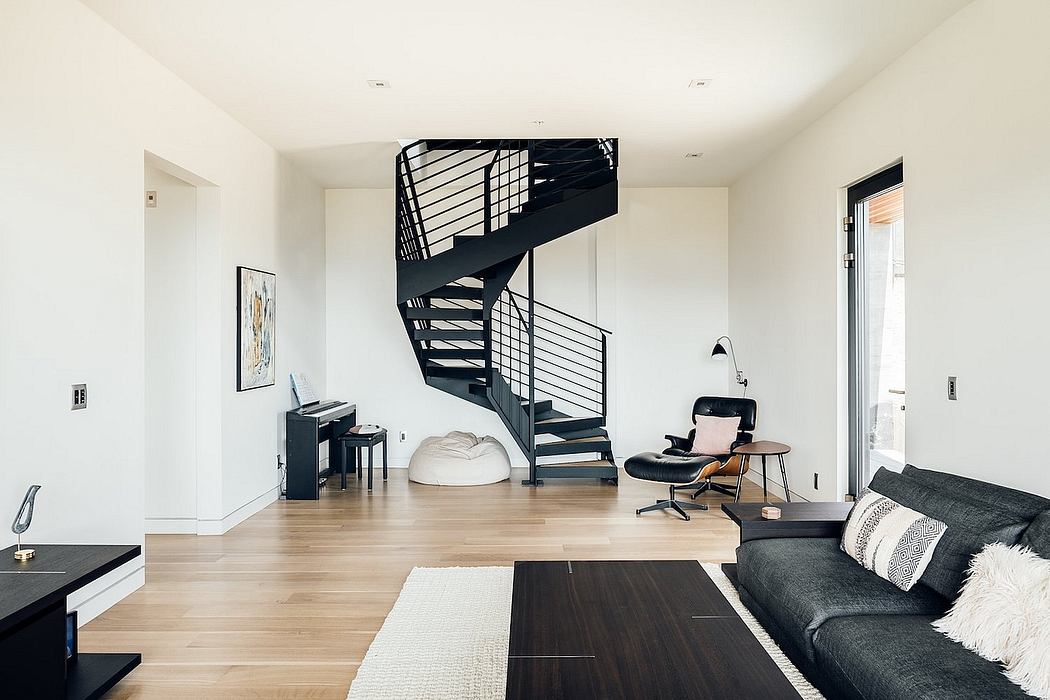 A modern, open-concept living space with a black spiral staircase, minimalist decor, and hardwood flooring.
