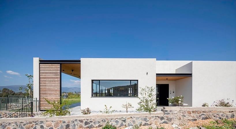 Modern minimalist home with clean lines, large windows, and natural stone facade.