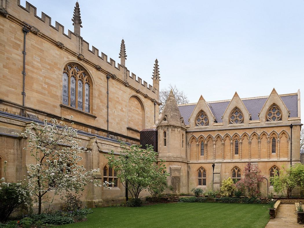 Ornate Gothic architecture with pointed arched windows, towers, and a well-manicured garden.
