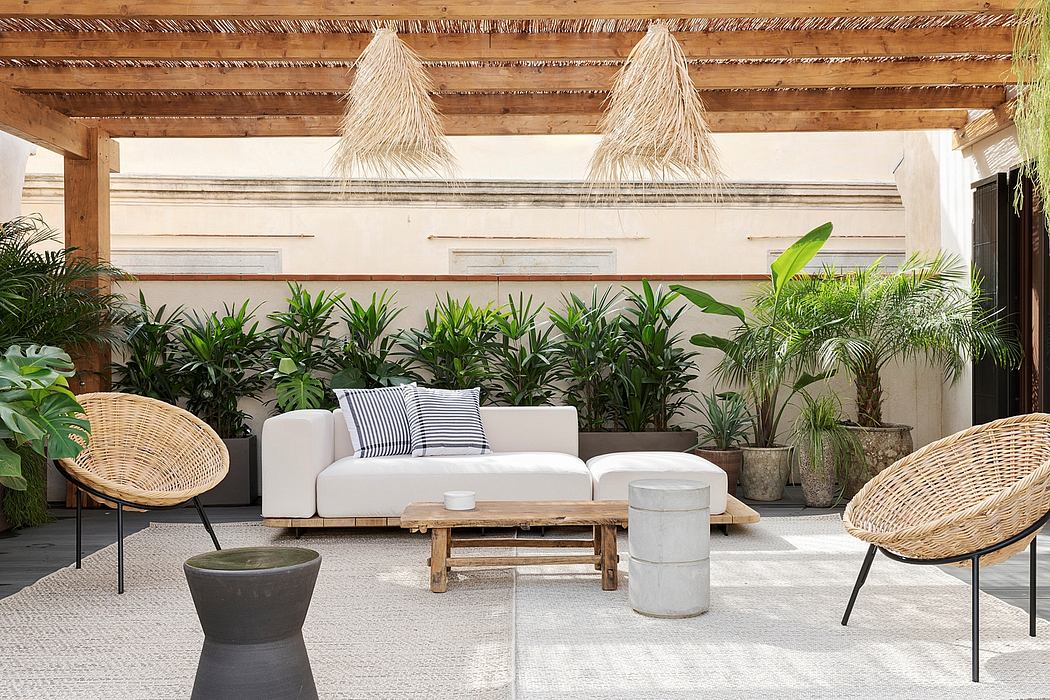 Tropical-inspired outdoor living space with thatched roof, lush greenery, and rustic furnishings.