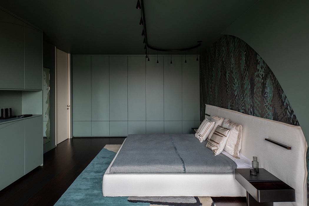Moody, minimalist bedroom with stone accent wall, built-in cabinetry, and pendant lighting.