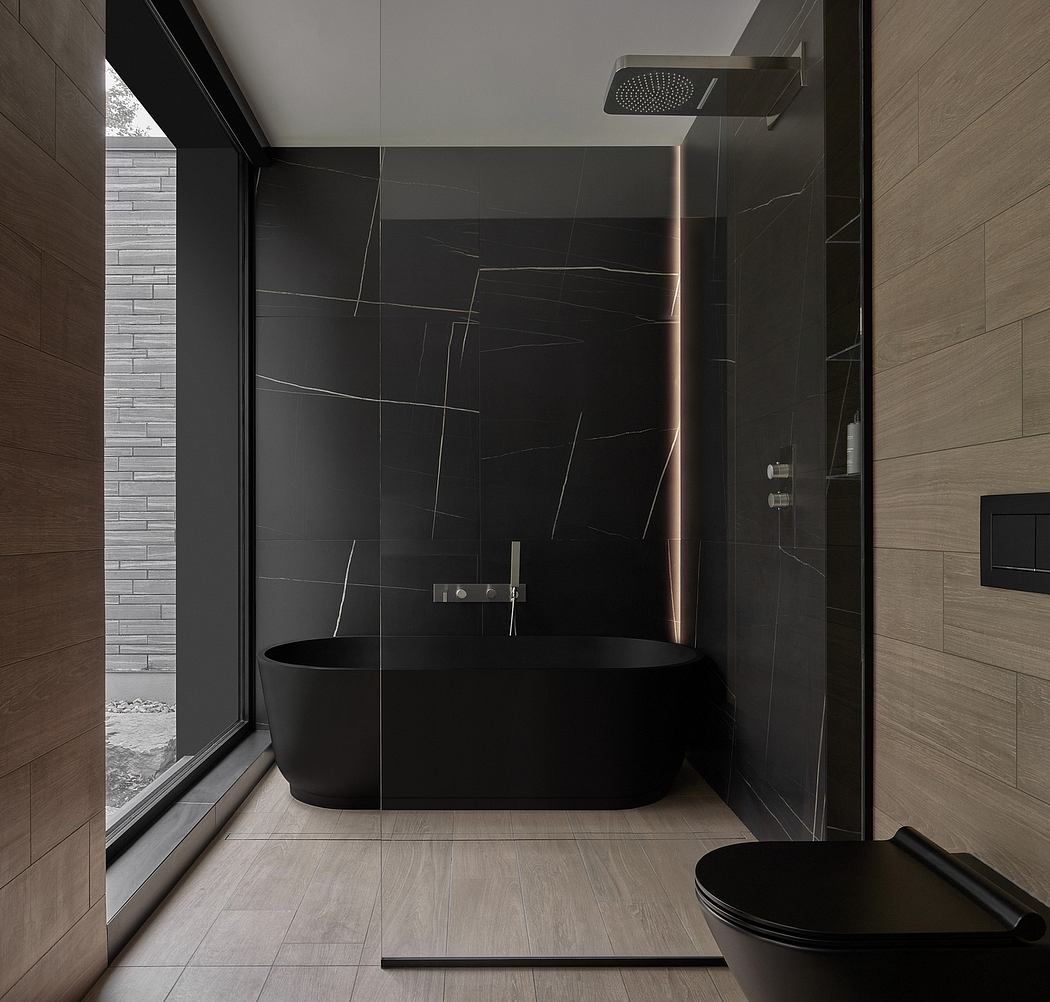 A modern bathroom with a black freestanding bathtub, large tile panels, and a glass shower.