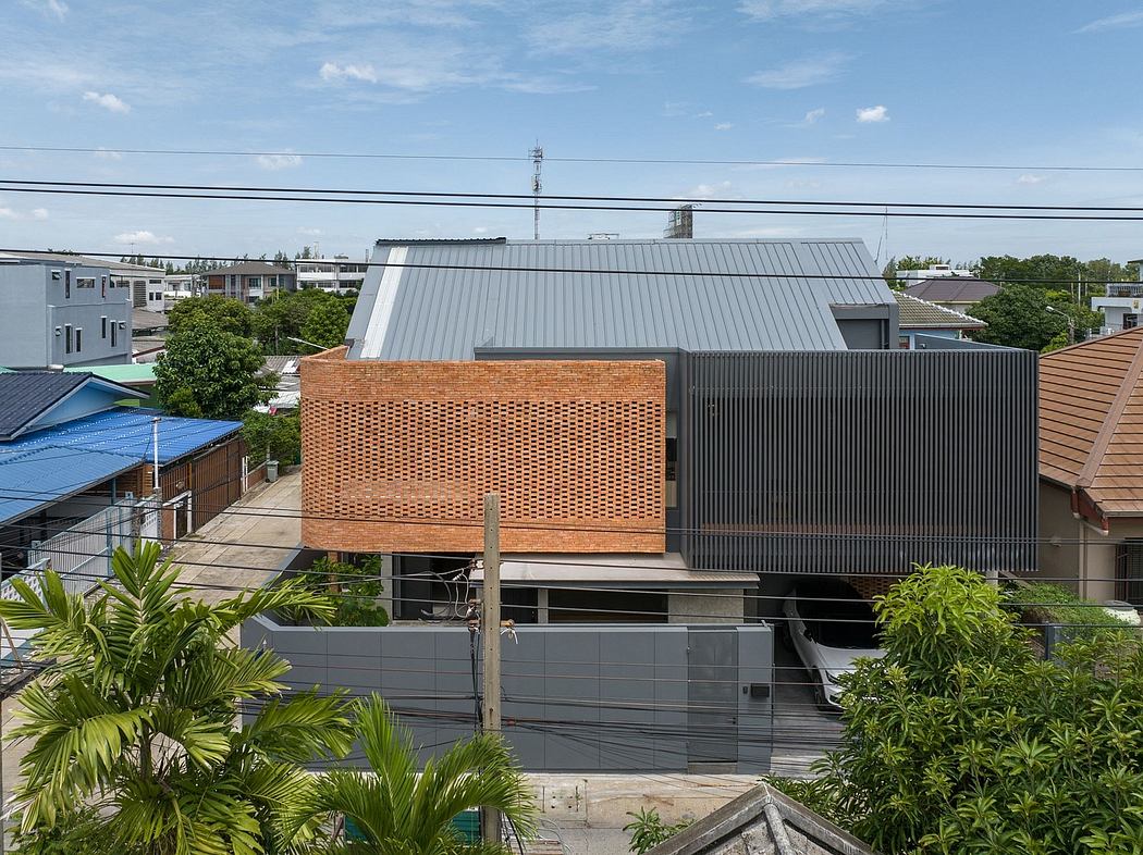 Distinctive modern architecture with brick facade, metal roof, and palm trees.