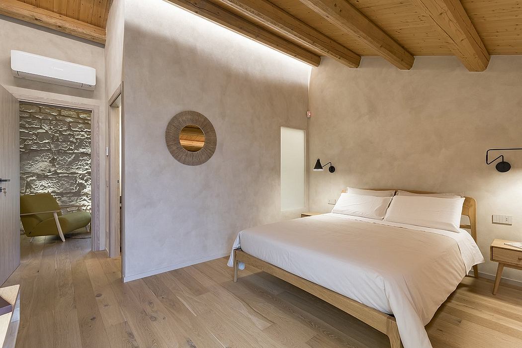 Minimalist bedroom with rustic wooden beams, textured walls, and modern furnishings.