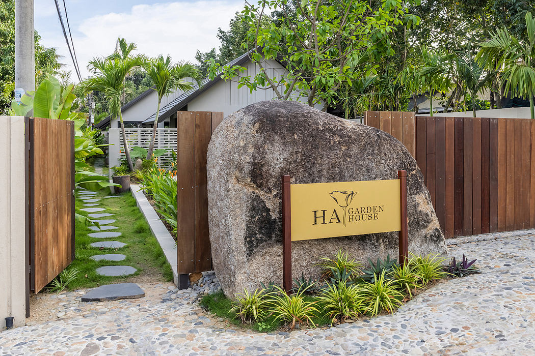 A cozy garden house surrounded by lush greenery and a paved pathway leading to the entrance.