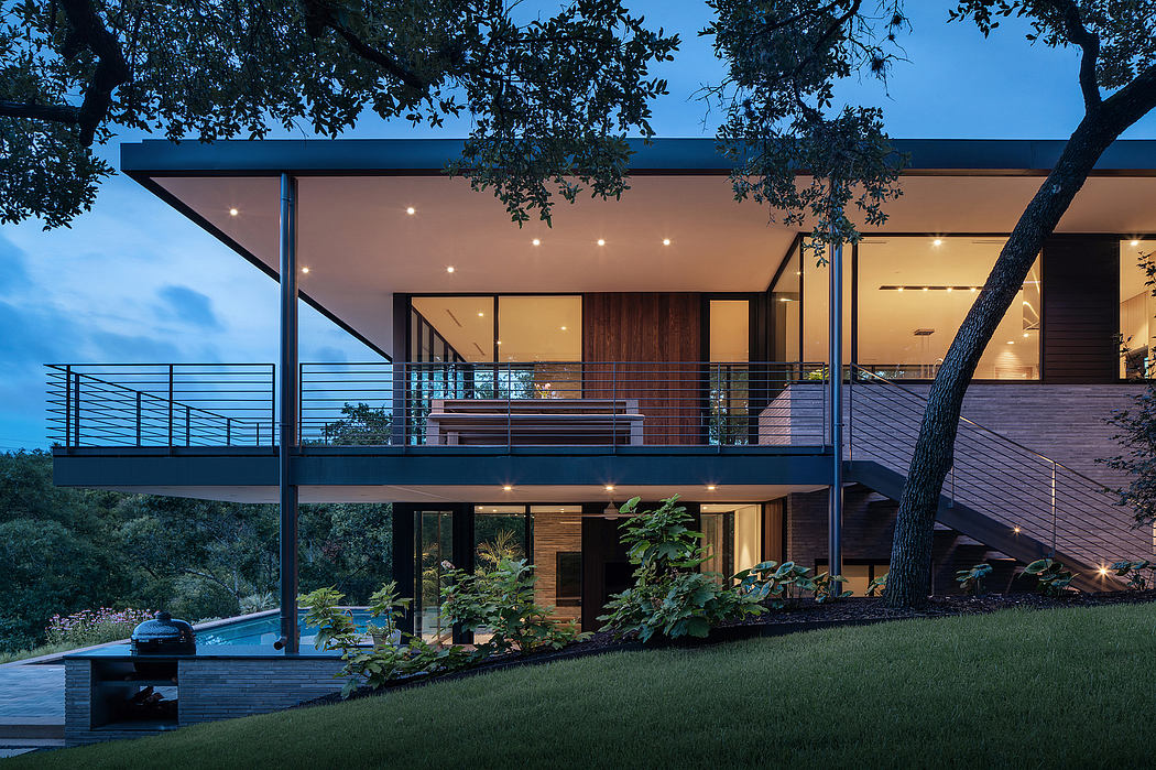 A modern two-story home with a sleek exterior, large windows, and a wraparound balcony.