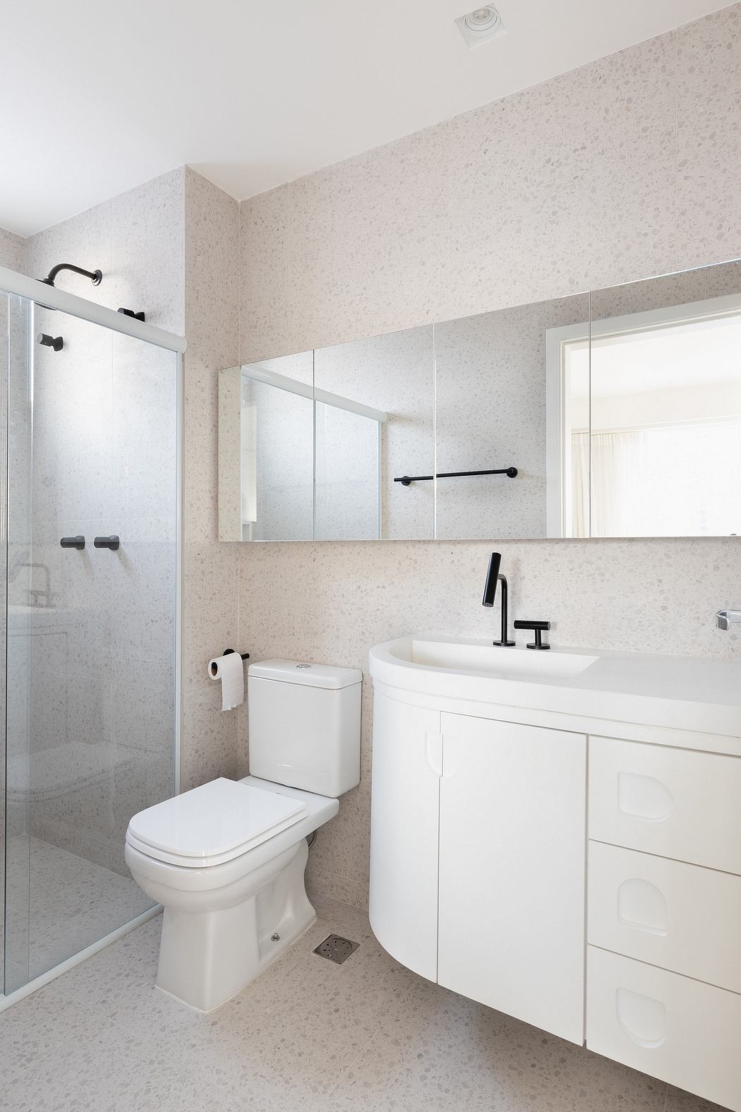 Modern, minimalist bathroom with sleek white vanity, frameless mirrors, and tiled walls.