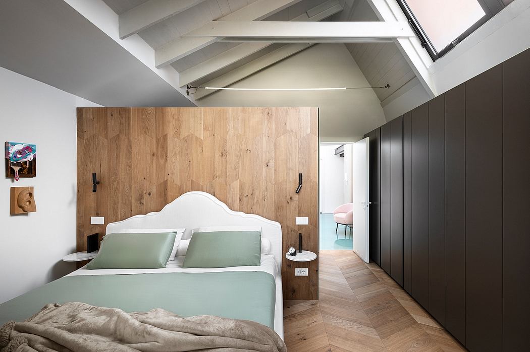 Spacious bedroom with wooden wall paneling, white headboard, and sleek black cabinets.