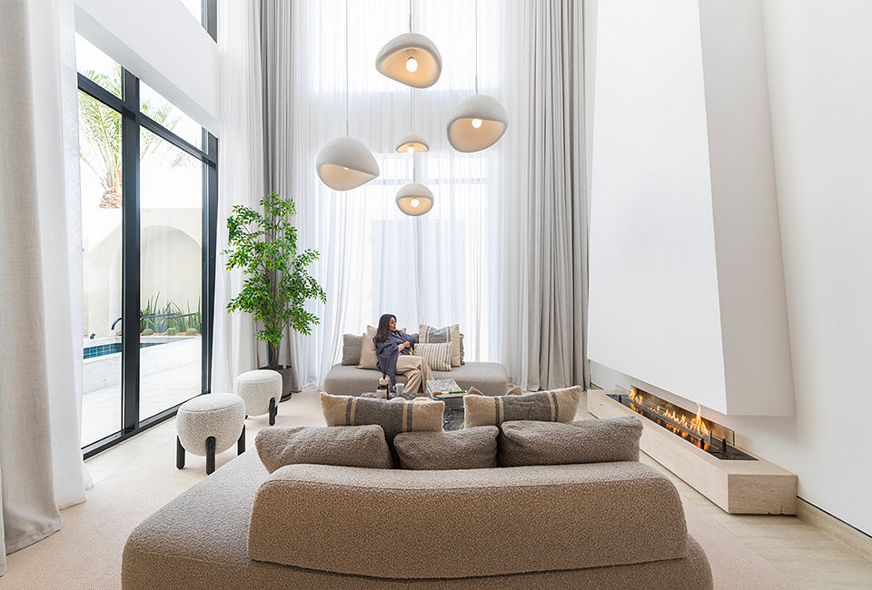 Spacious, modern living room with sleek lighting fixtures, plush seating, and a fireplace.