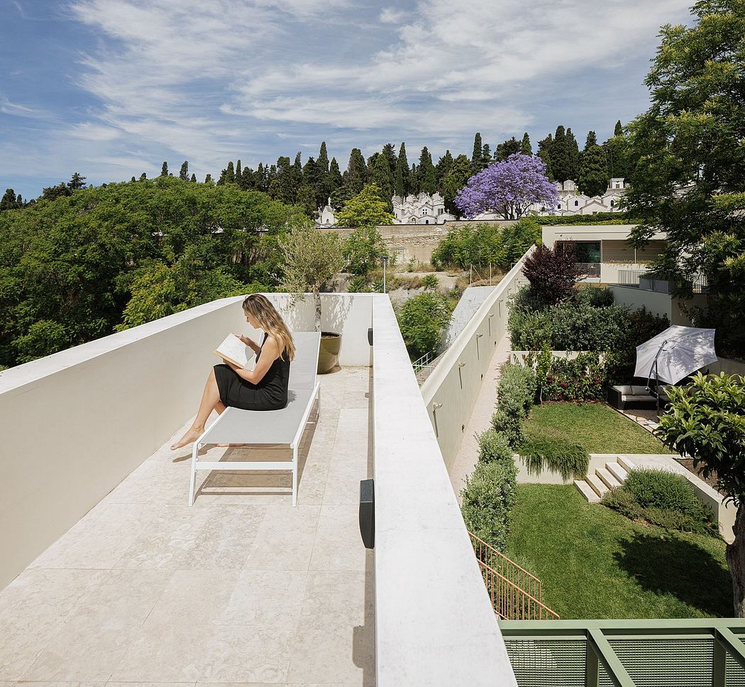 A modern, minimalist balcony with lush green landscape and lavender trees in the distance.