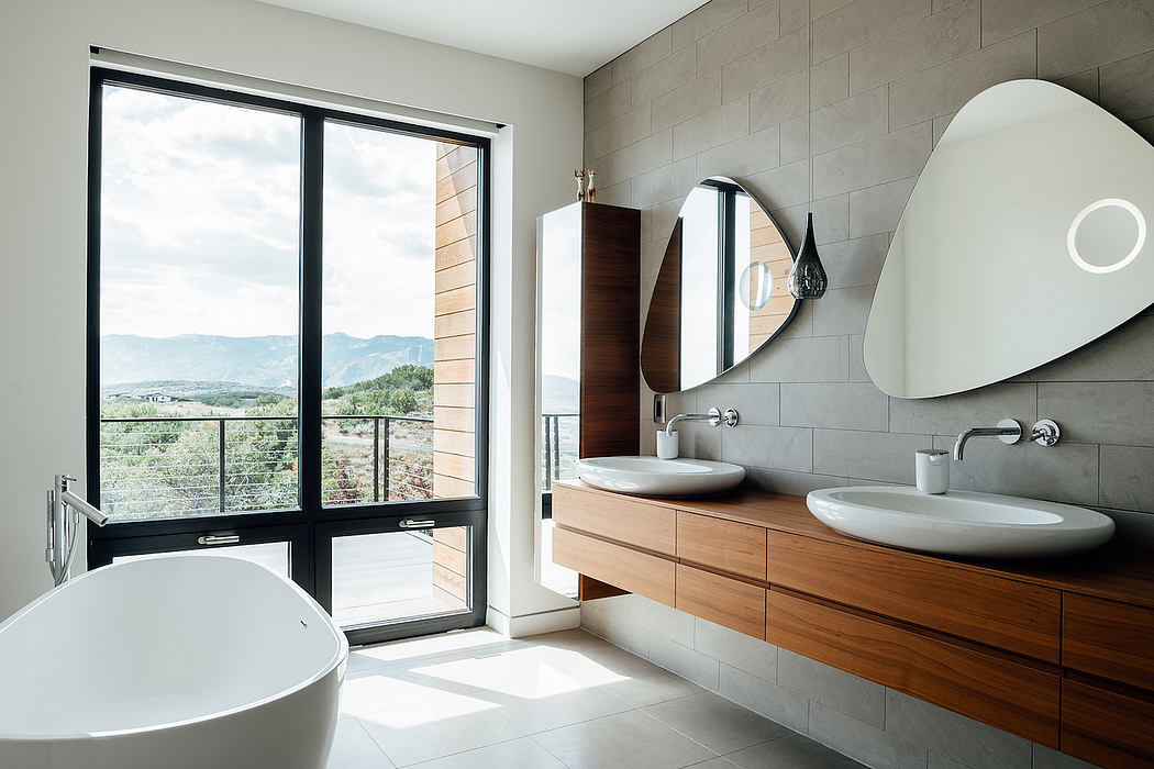 Sleek and spacious bathroom with wooden vanity, large mirror, and expansive mountain views.