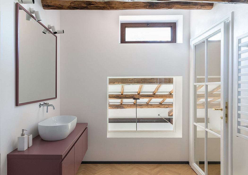 A modern bathroom with wooden beams, a sleek vanity, and a decorative mirror.