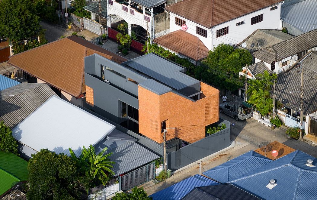 Aerial view of a modern, multi-story brick building with distinctive roofing and landscaping.