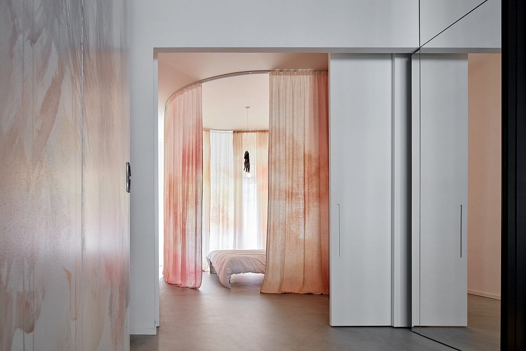 Minimalist room with arched curtain dividers, white walls, and sliding closet doors.