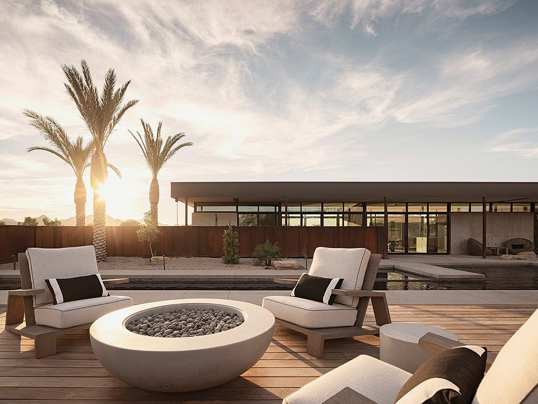 Minimalist outdoor seating area with fire pit, modern architecture, and palm trees.