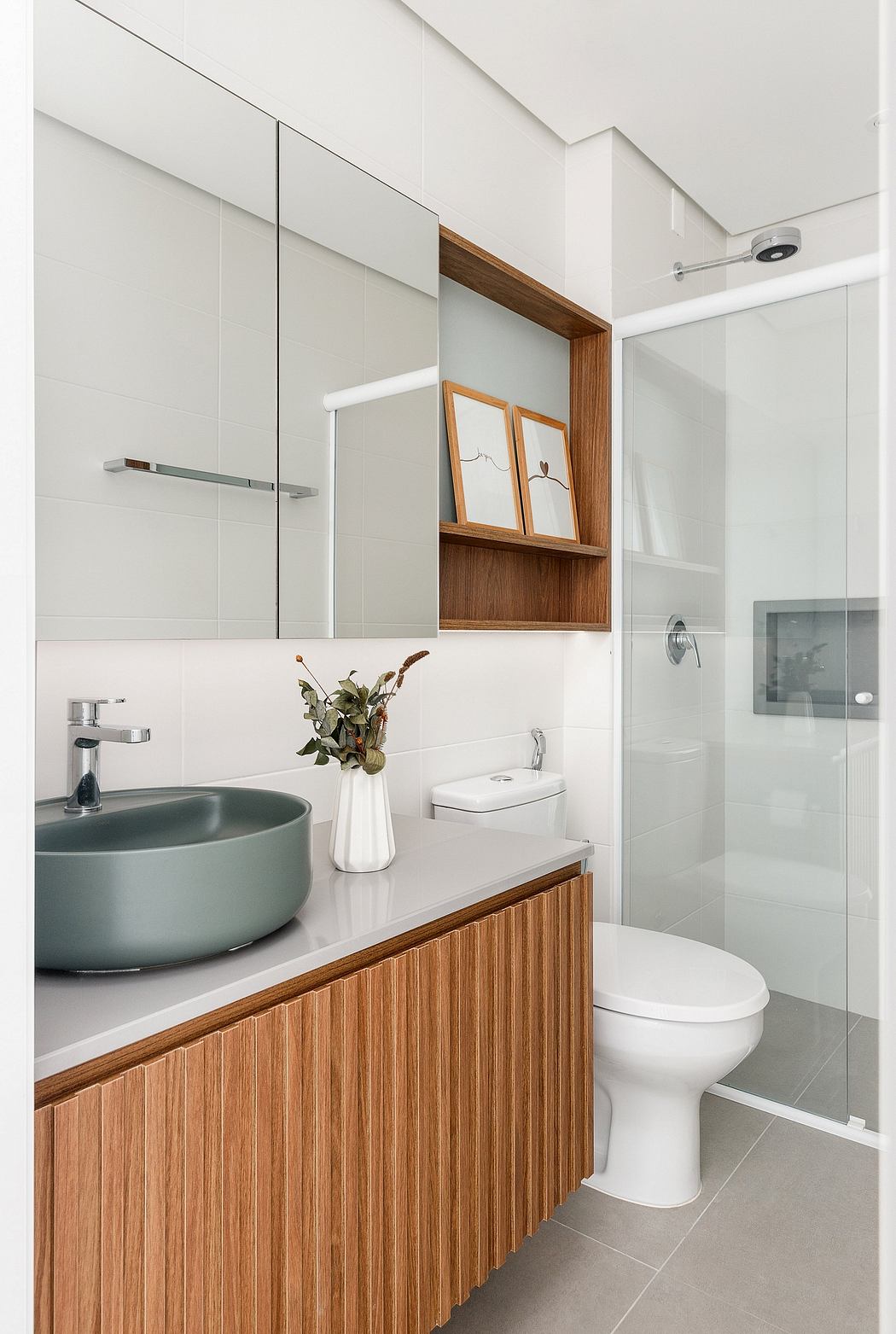 Minimalist bathroom design with wooden vanity, vessel sink, and recessed shelving.