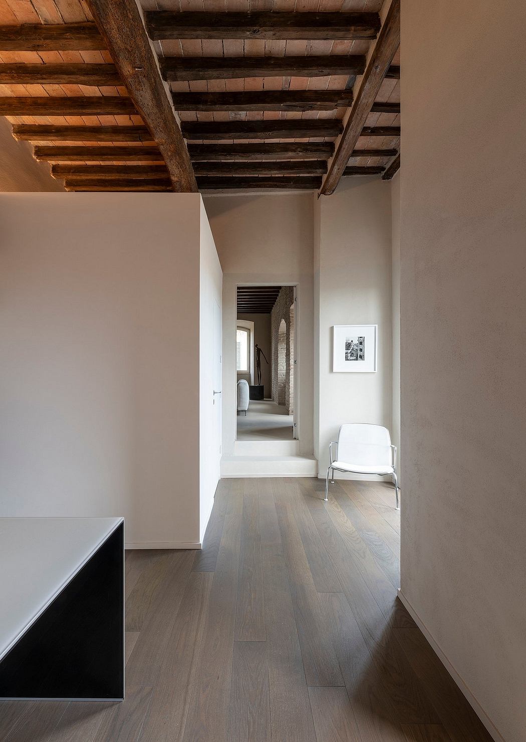 Rustic wooden beams contrast with modern, minimalist interior design.