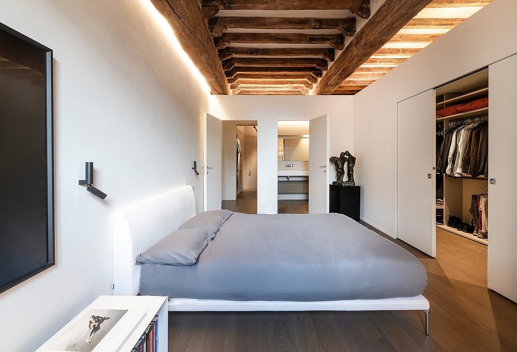 A modern bedroom with rustic wooden beams, minimalist decor, and an open floor plan.