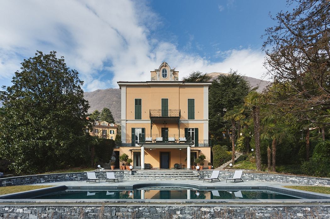 Elegant 3-story villa with ornate facade, pool, and lush greenery in mountainous setting.