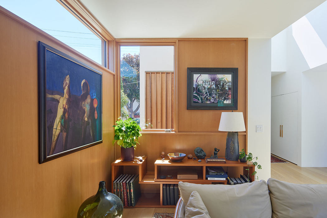 Well-lit living room with wooden paneling, modern artwork, and built-in shelving.