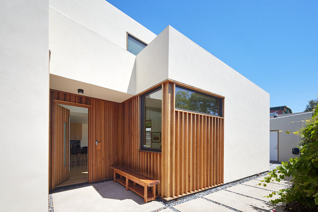 Modern architectural design featuring clean lines, contrasting wood and white facade.