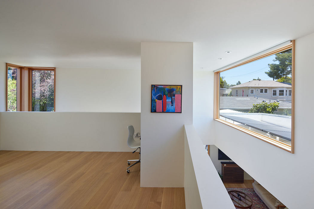 Minimalist home office with large window overlooking a residential neighborhood.