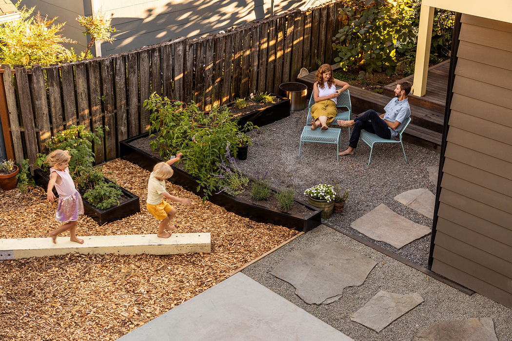Well-designed backyard with gardening beds, paving stones, and cozy seating area.