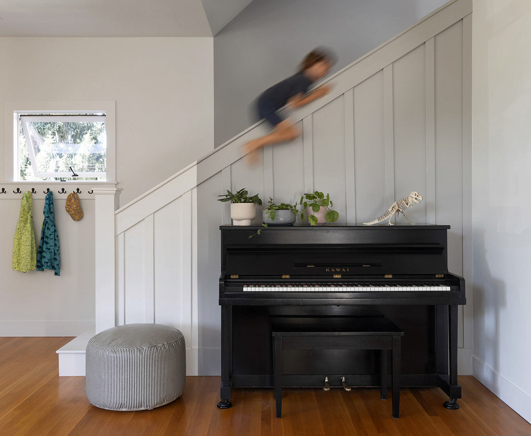 Cozy entryway with paneled walls, piano, and potted plants inviting one inside.